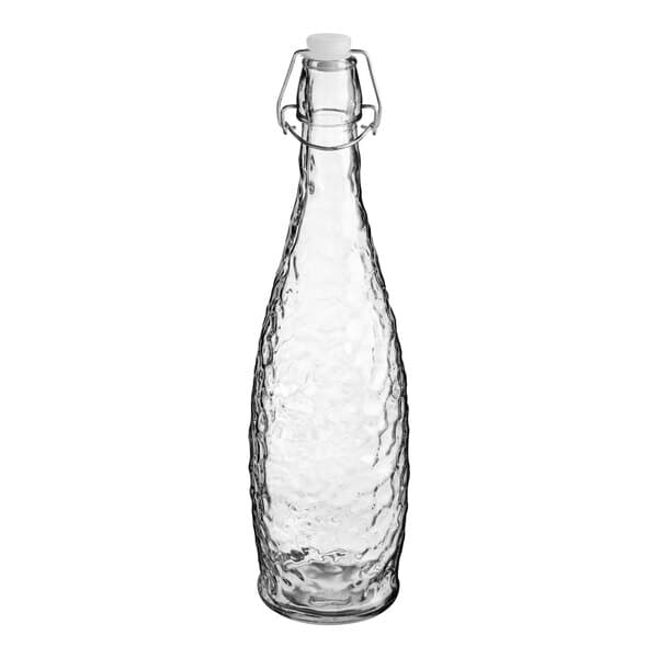 An Acopa clear glass water bottle with a clear swing top lid.