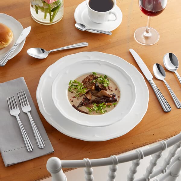 A silver table with Acopa Harmony stainless steel forks, knives, and spoons.