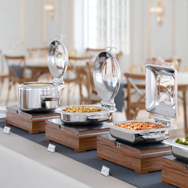 An Acopa Voyage stainless steel soup chafer with a glass top on a buffet table.