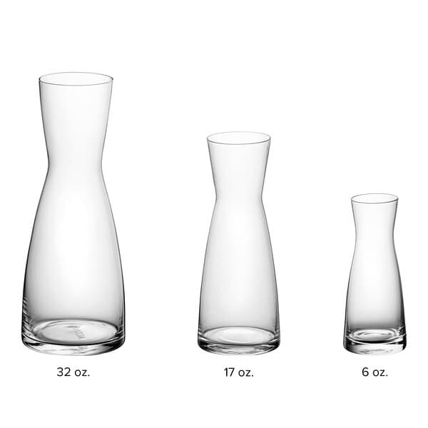 Acopa glass carafes with white caps on a white background.