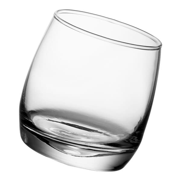 An Acopa Select rocking rocks glass with a small amount of liquid in it.