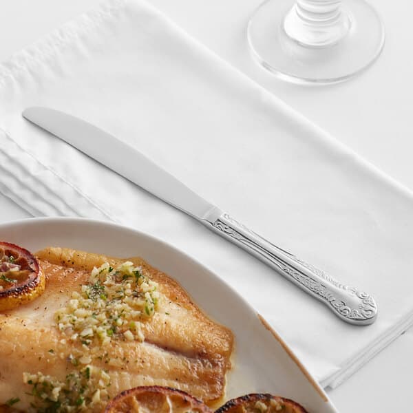 a plate of food on a napkin next to a glass of water