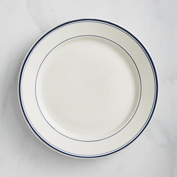 An Acopa ivory stoneware plate with wide rim and blue lines.