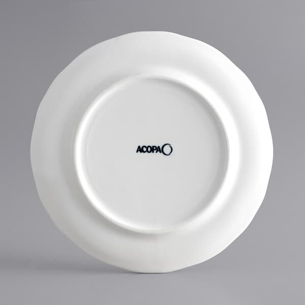 An Acopa Condesa white porcelain plate with scalloped edges and a wide rim.