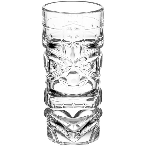 A close-up of a clear Acopa tiki glass with a face design.