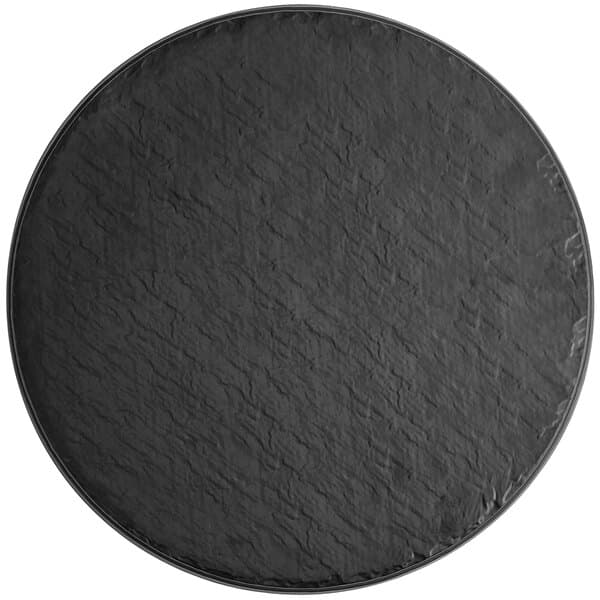 A black round Acopa melamine tray with a black rim.