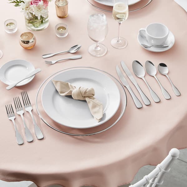 A table set with plates, silverware, and water glasses with ice.